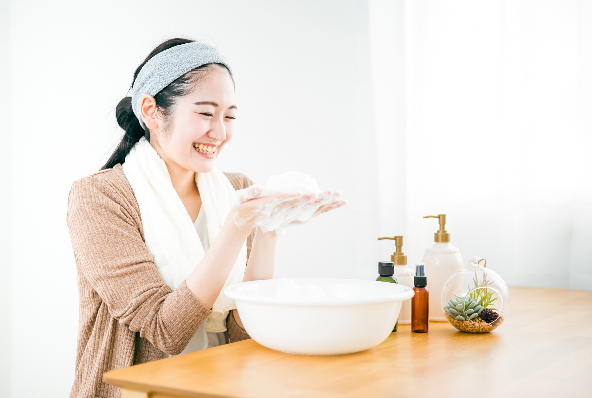 たっぷりの泡で洗顔の準備をする笑顔の女性