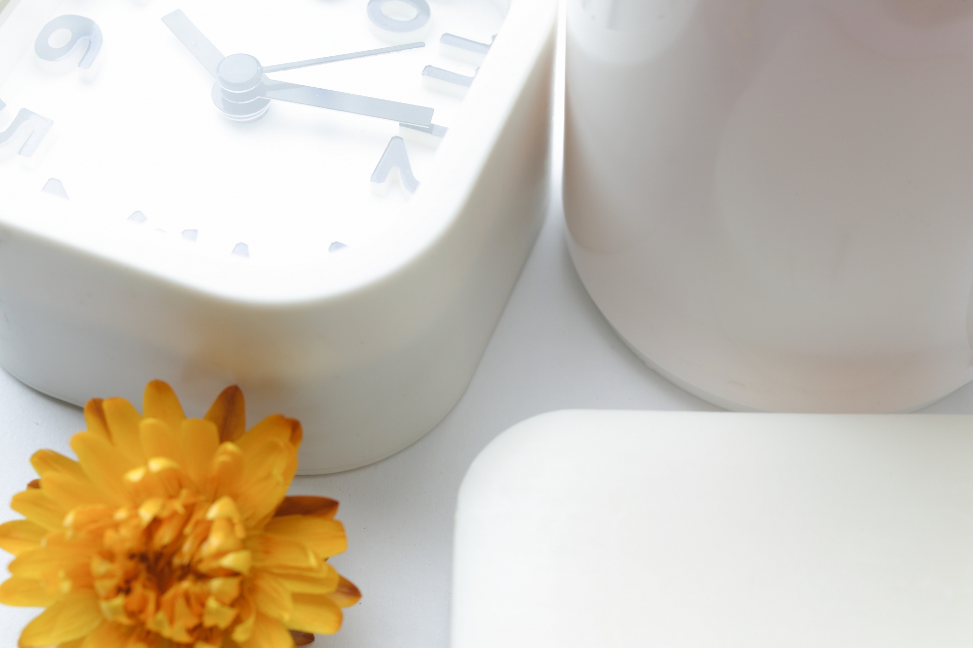 朝の支度の時間をイメージさせる白い時計と黄色い花