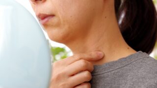 たるみや年齢サインが気になる首元をチェックする女性
