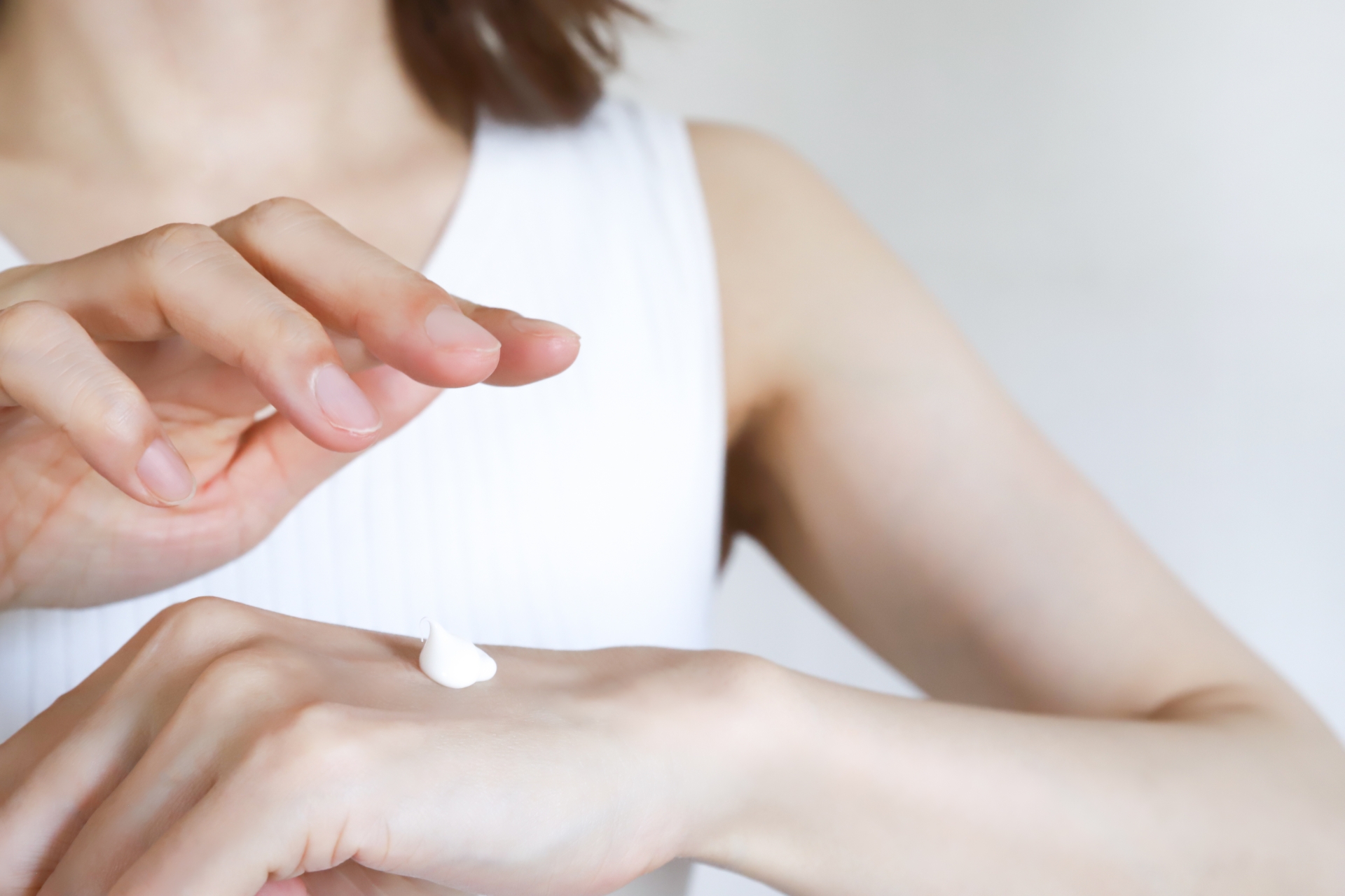 手の甲に適量の日焼け止めクリームを取り出す様子