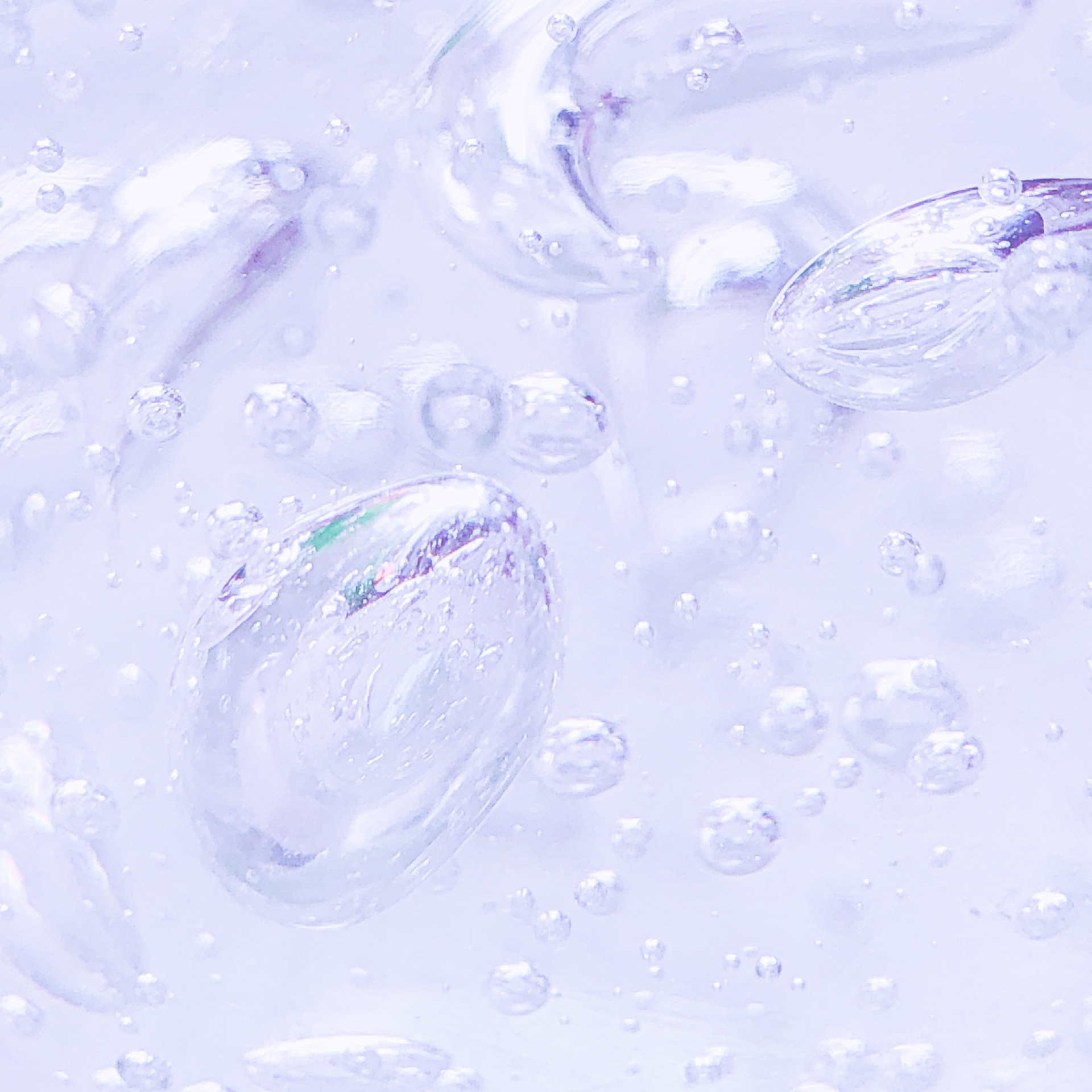 薄紫色に透き通ったジェル状の液体の中に、大小さまざまな気泡が浮いているクローズアップ画像。