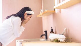 洗面台で肌のケアを自力で行う女性。自宅で実践できる正しいスキンケアのイメージ