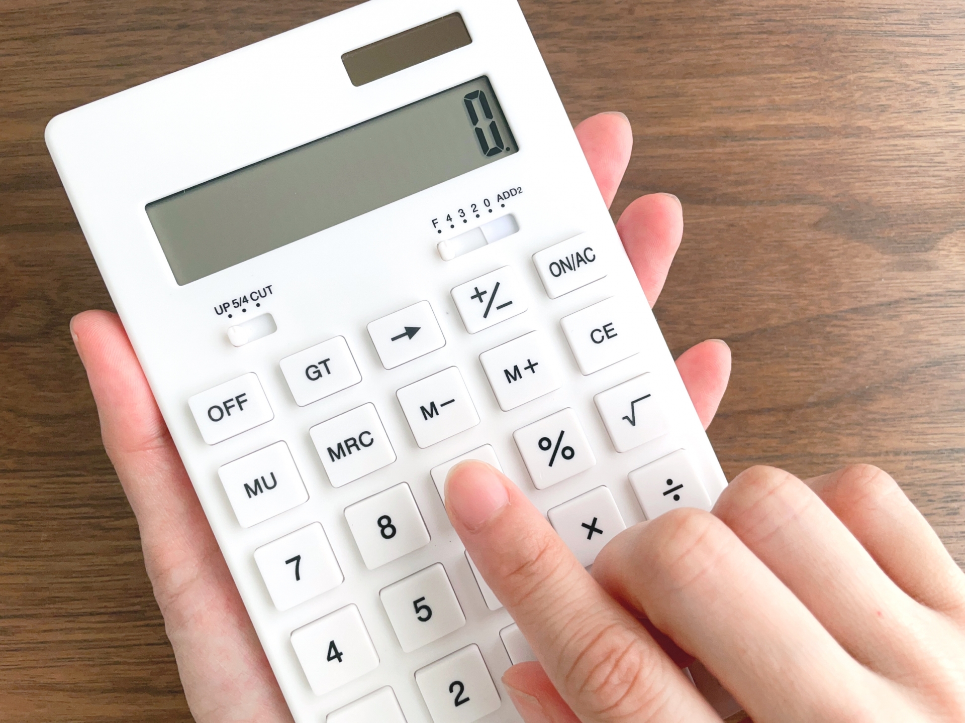 基礎代謝量を計算する様子をイメージした、電卓を操作する手元の写真