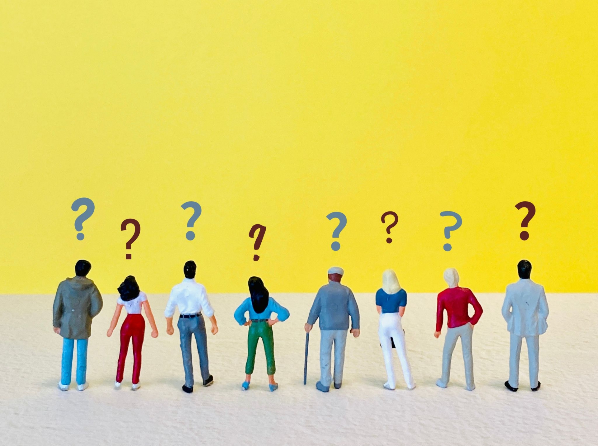さまざまな人々のフィギュアと、その頭上に浮かぶクエスチョンマーク。
