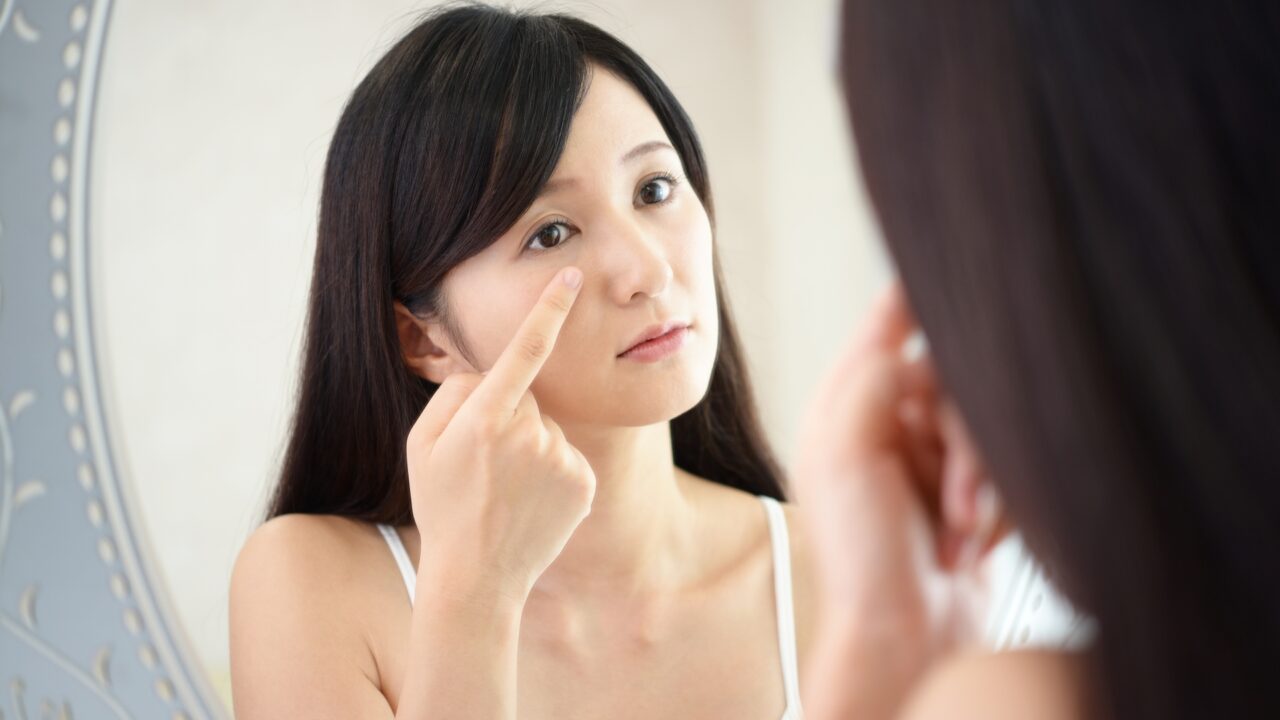 毛穴悩みのある頬の肌をチェックする女性