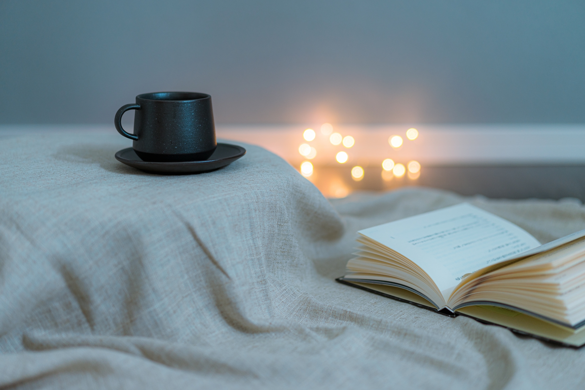 温かい飲み物と読書を楽しむ落ち着いた夜の風景。生活習慣を整え、ストレスを緩和するリラックスシーンのイメージ写真。
