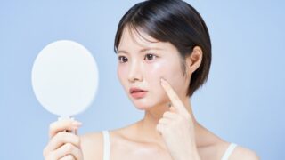 鏡を見ながら、気になる肌の乾燥やつっぱりを確認している女性の顔のアップ