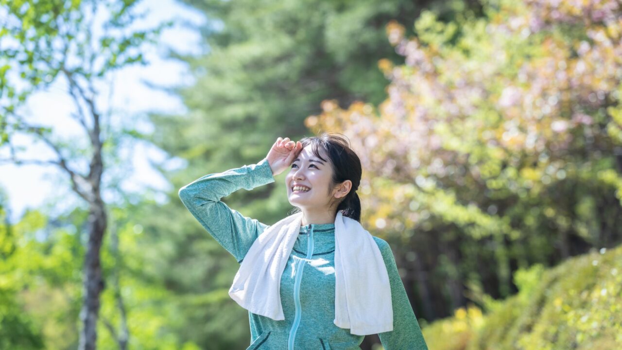 汗をかく夏の季節に、健やかな肌で笑顔を見せる女性のイメージ
