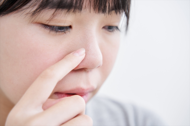 小鼻の毛穴や肌のざらつきを気にする女性のイメージ。