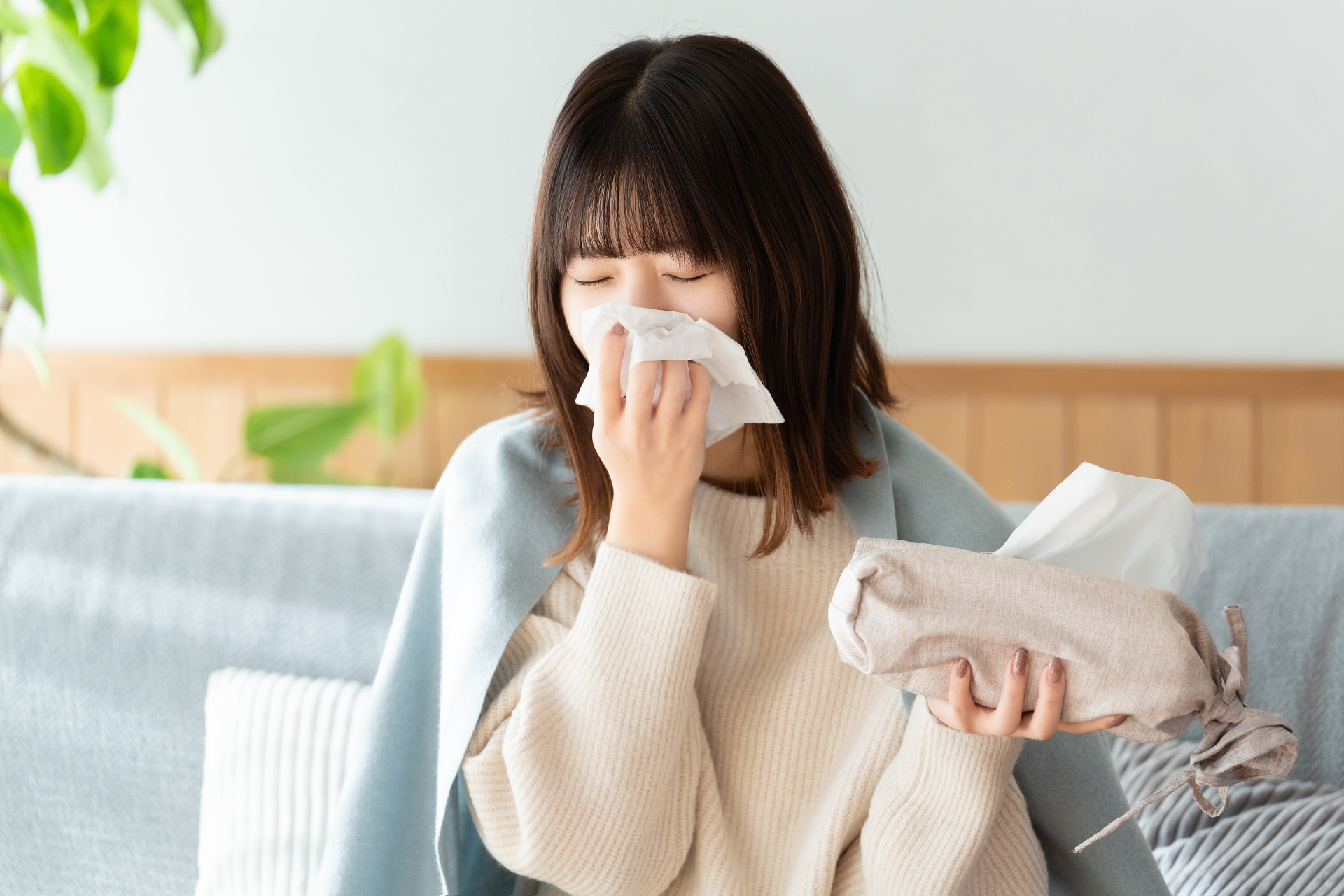 ティッシュで鼻を押さえながら体調不良や免疫力低下のサインに悩む女性