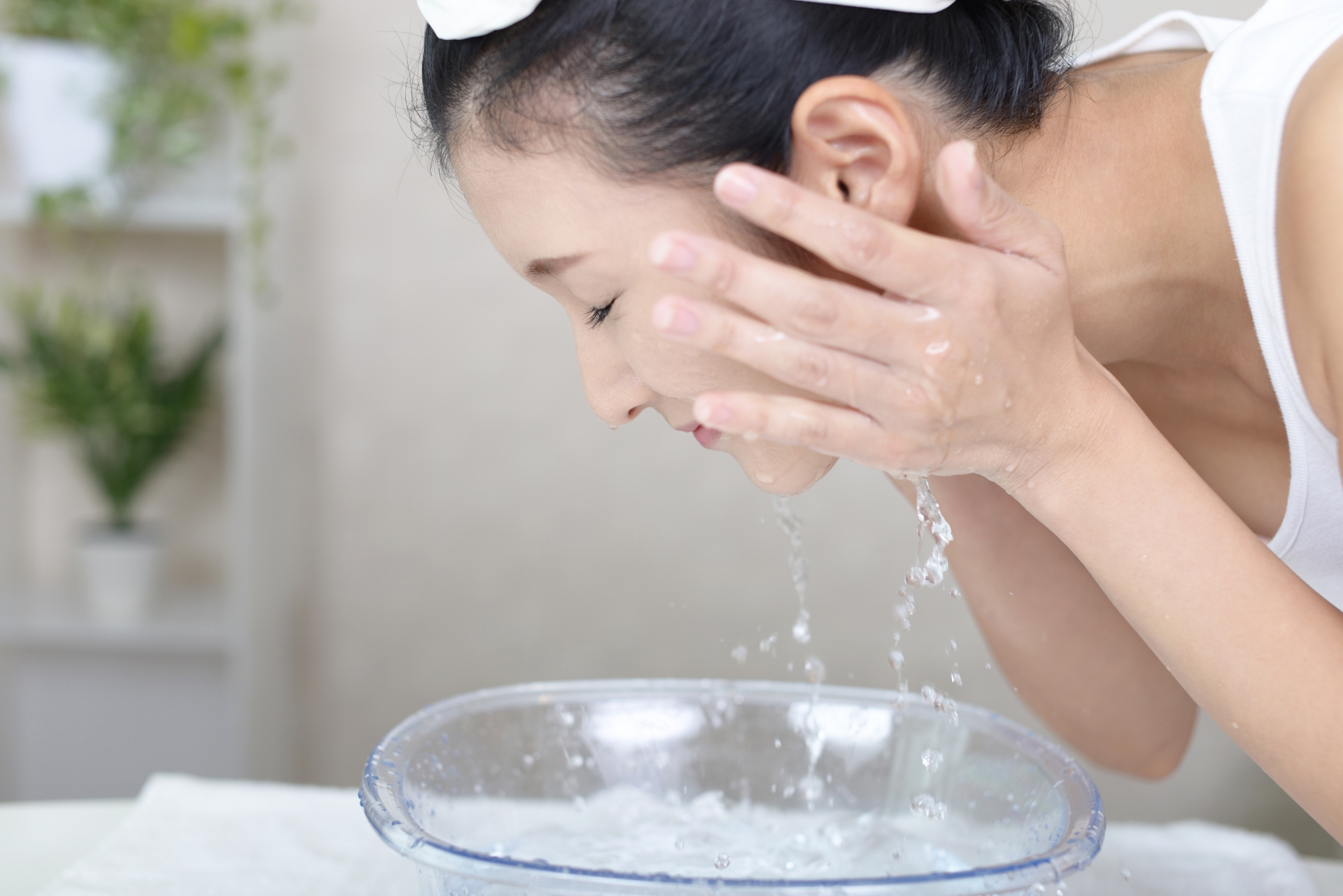 水やぬるま湯で優しく顔をすすぐ女性