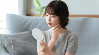 自分の肌状態や乾燥トラブルをチェックする女性
